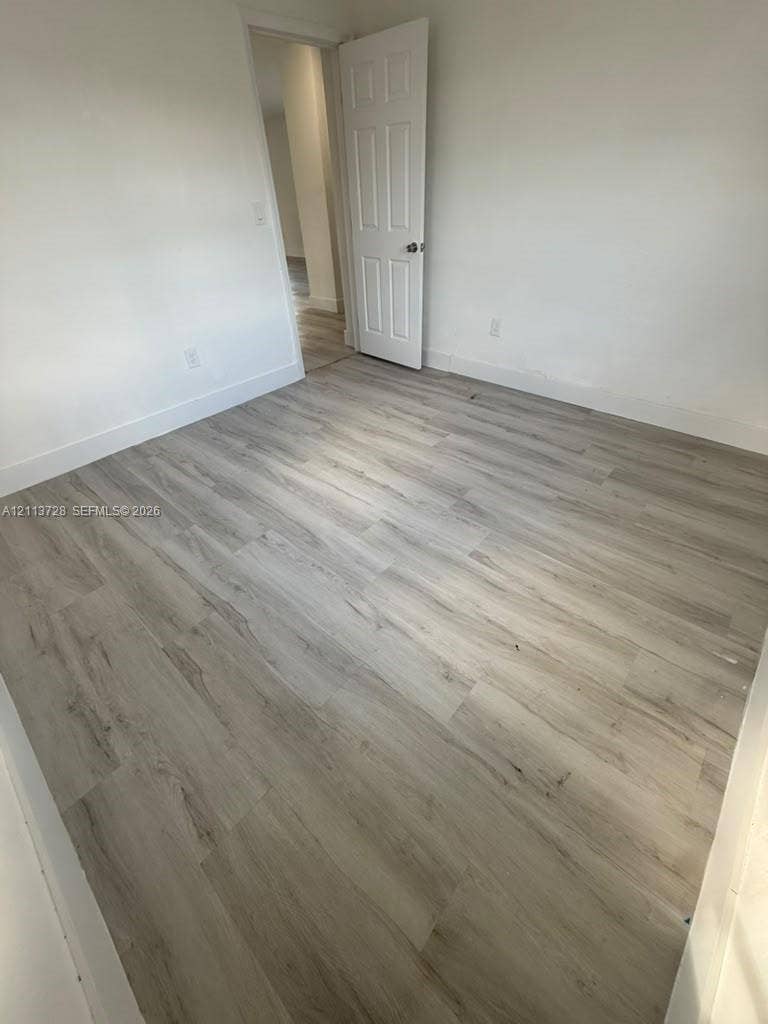 9200 SW 37th Street, Miami, FL 33165 Room featuring wood-finish flooring, neutral walls, and a six-panel door