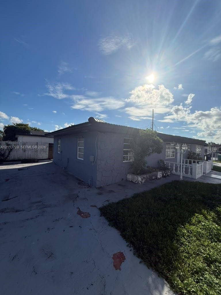 9200 SW 37th Street, Miami, FL 33165 Exterior featuring a textured stone veneer facade, a covered porch with a concrete balustrade, and a paved driveway