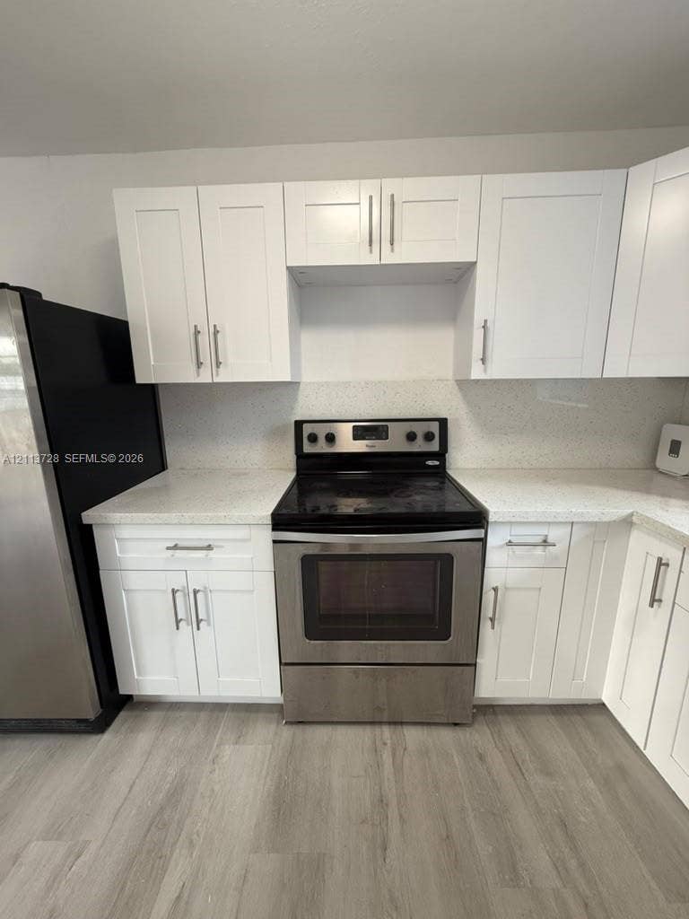 9200 SW 37th Street, Miami, FL 33165 Kitchen featuring white shaker-style cabinetry, speckled stone-composite countertops, stainless steel electric range, and wood-finish flooring