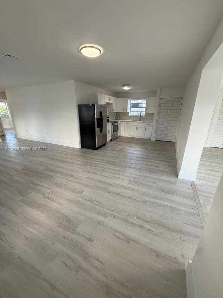 9200 SW 37th Street, Miami, FL 33165 Kitchen featuring white shaker-style cabinetry, stainless steel side-by-side refrigerator, smooth-top range, and wood-finish flooring