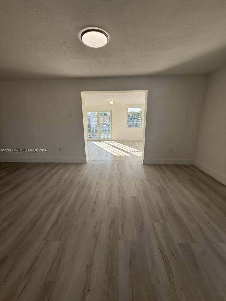 9200 SW 37th Street, Miami, FL 33165 Neutral-toned wood-finish flooring, flush-mount ceiling light fixture, and glass-paneled double doors