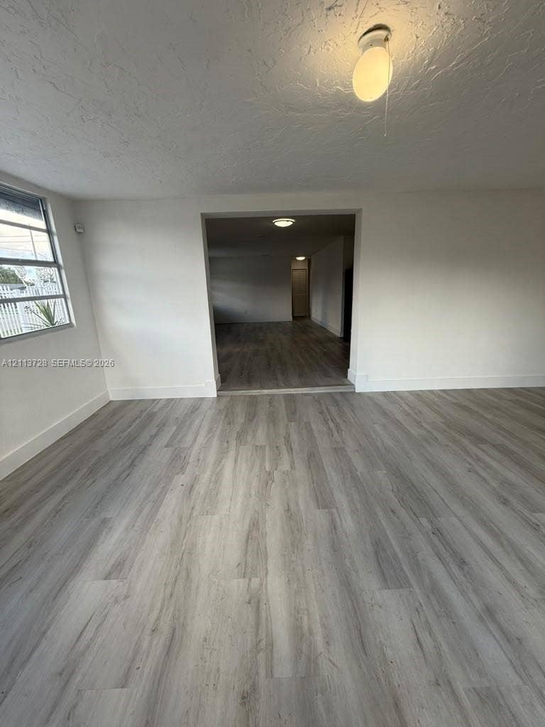 9200 SW 37th Street, Miami, FL 33165 Neutral-toned wood-finish flooring, multi-pane window with metal frame, and ceiling-mounted light fixtures
