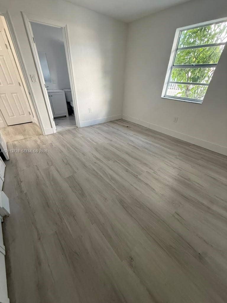 9200 SW 37th Street, Miami, FL 33165 Room featuring wood-finish flooring, a multi-pane window, and a multi-panel interior door