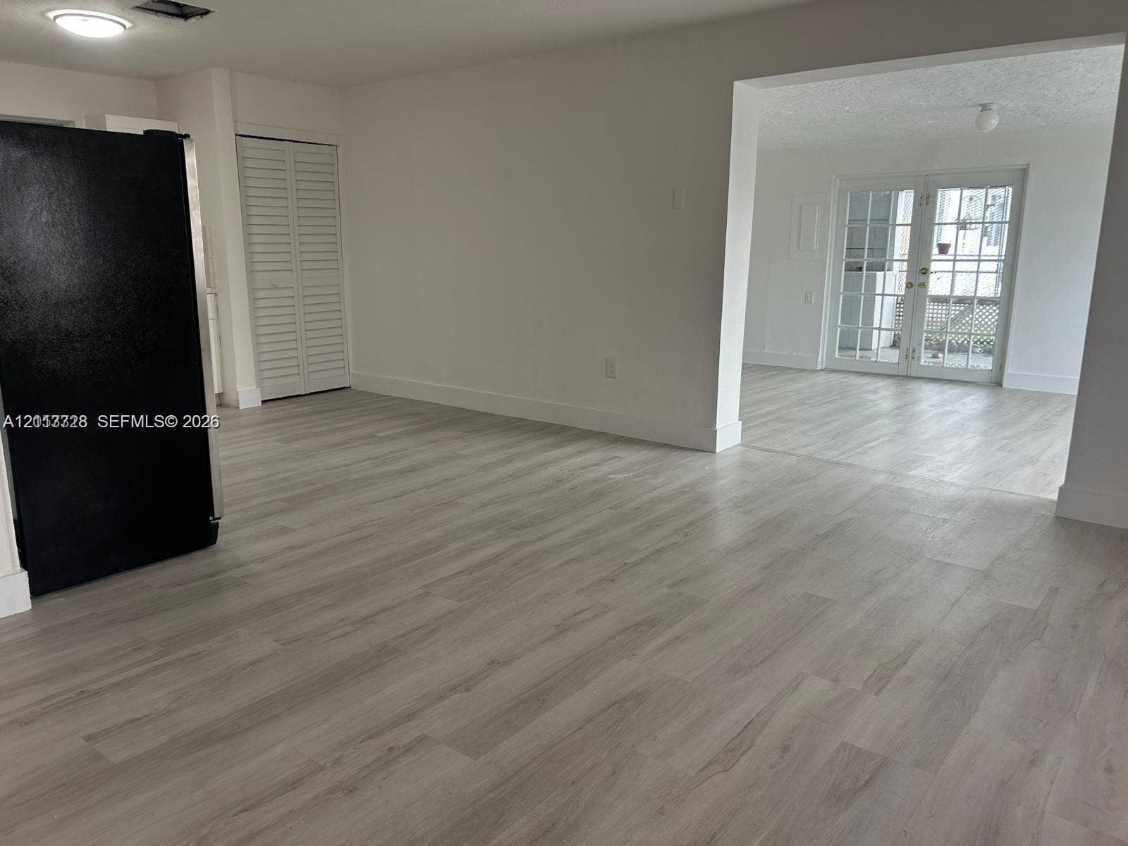 9200 SW 37th Street, Miami, FL 33165 Wood-finish flooring, white louvered closet doors, and French doors with glass panes