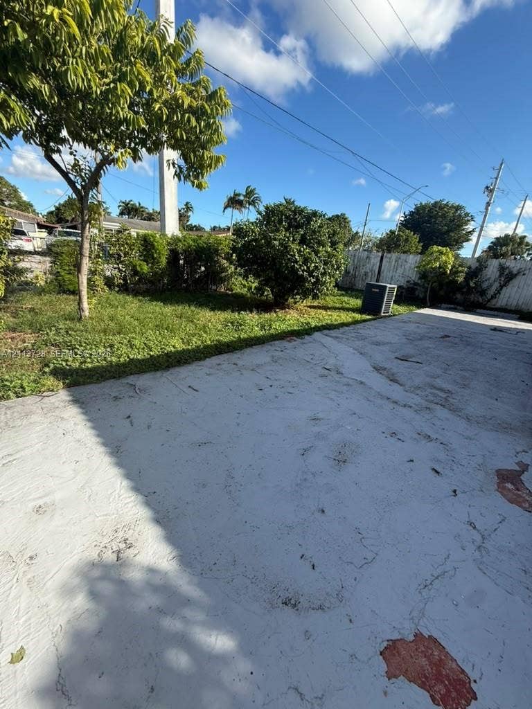 9200 SW 37th Street, Miami, FL 33165 Concrete patio featuring a perimeter of mature landscaping and a privacy fence