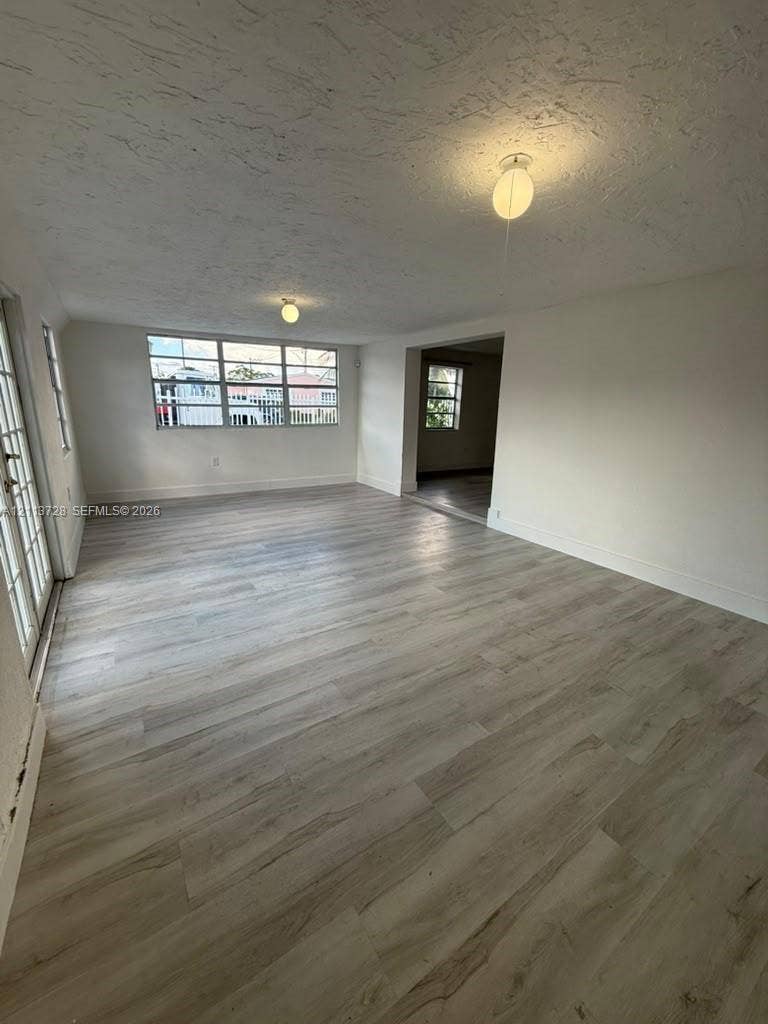9200 SW 37th Street, Miami, FL 33165 Interior space featuring wood-finish flooring, multi-pane windows, smooth-finish ceiling, and dual flush-mount light fixtures