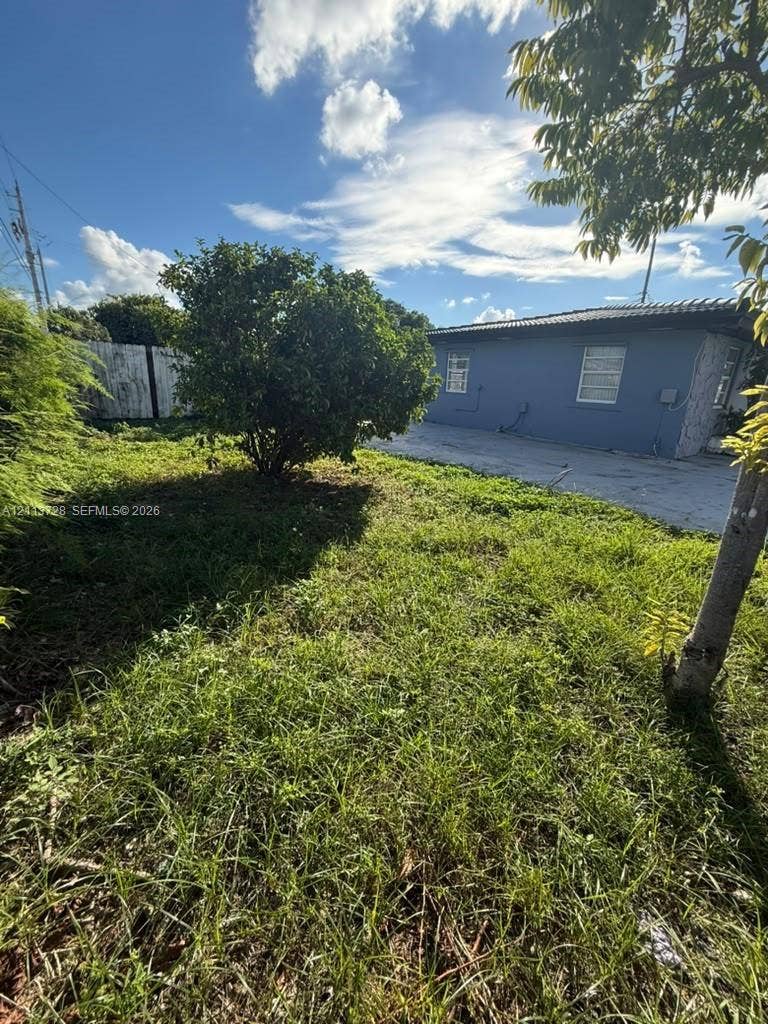 9200 SW 37th Street, Miami, FL 33165 Exterior grounds featuring a concrete driveway, mature trees, and a concrete perimeter fence
