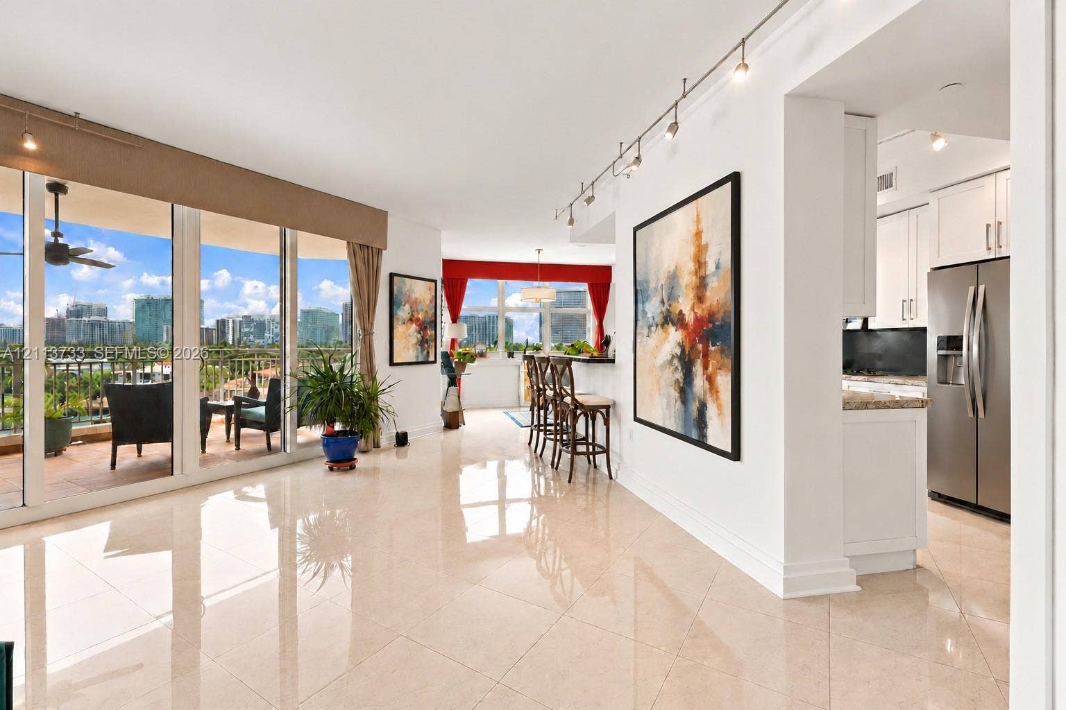 9751 E Bay Harbor Drive, #6A, Bay Harbor Islands, FL 33154 Custom reach-in closet featuring extensive built-in light wood cabinetry, multiple open shelving tiers, integrated drawers with metal hardware, and dual-level hanging rods