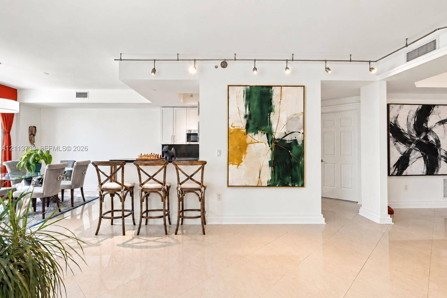 9751 E Bay Harbor Drive, #6A, Bay Harbor Islands, FL 33154 Open-concept interior featuring large-format tile flooring, recessed track lighting, and a kitchen breakfast bar