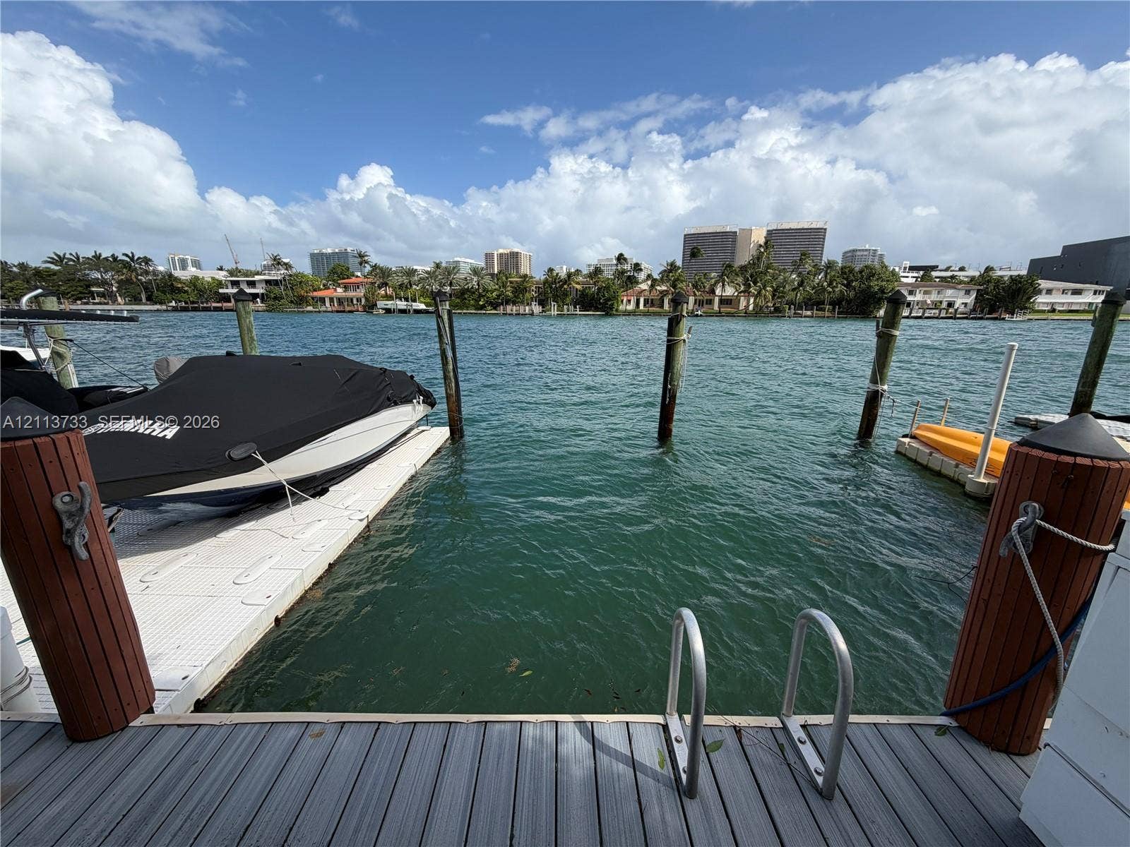 9751 E Bay Harbor Drive, #6A, Bay Harbor Islands, FL 33154 Waterfront bulkhead with integrated synthetic decking, pile-mounted mooring pilings, and stainless steel swimming ladder
