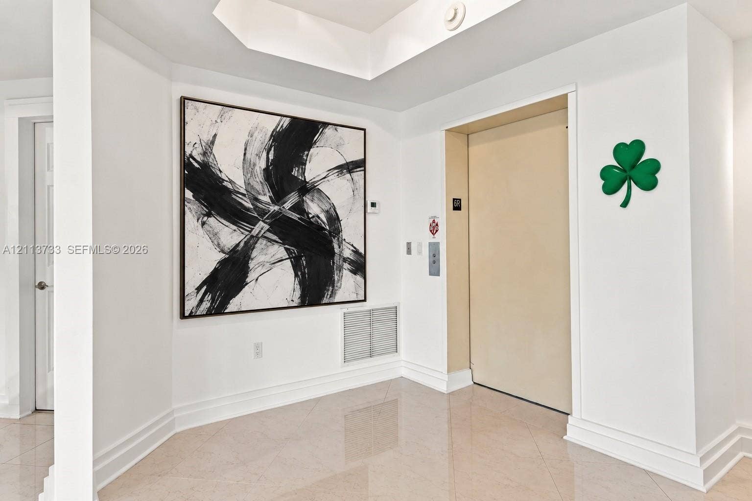 9751 E Bay Harbor Drive, #6A, Bay Harbor Islands, FL 33154 Foyer featuring large-format tile flooring, tray ceiling, and a private elevator access point