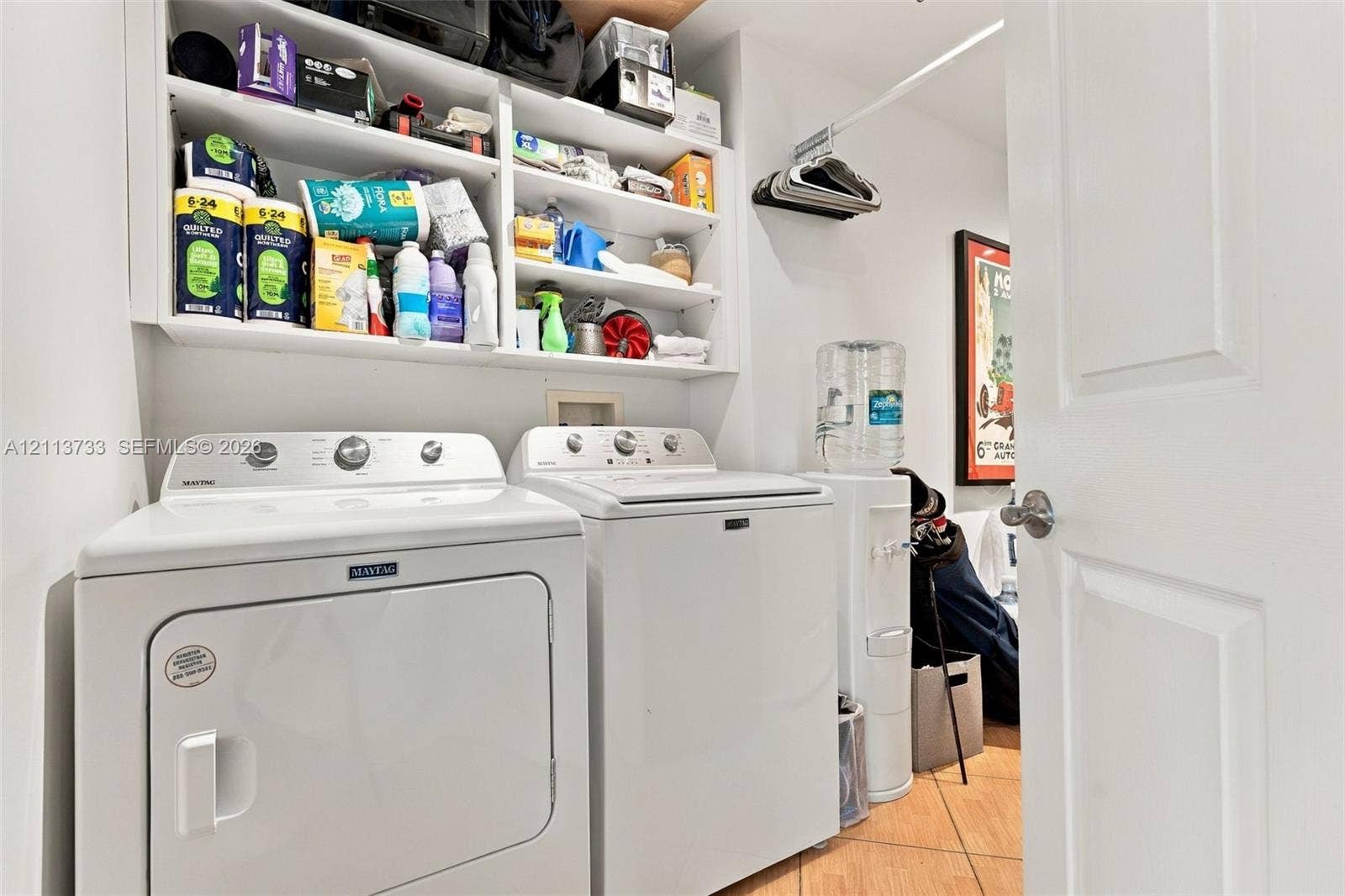 9751 E Bay Harbor Drive, #6A, Bay Harbor Islands, FL 33154 Private Utility space featuring tile flooring, built-in open shelving, and a wall-mounted clothing rod