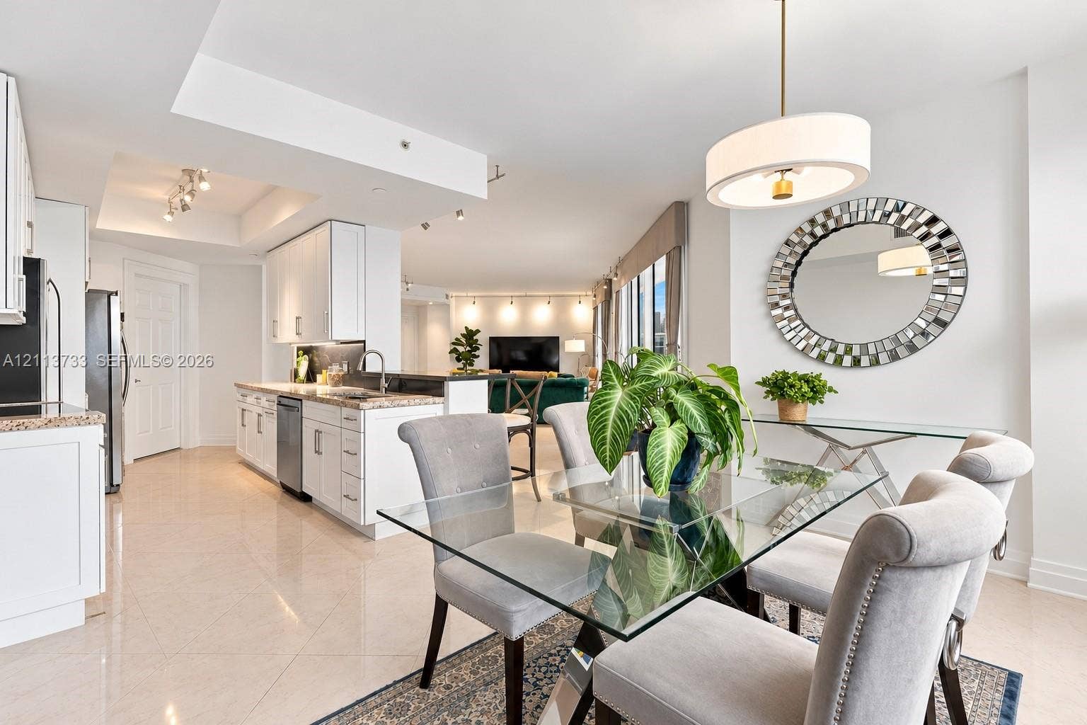 9751 E Bay Harbor Drive, #6A, Bay Harbor Islands, FL 33154 Kitchen featuring white cabinetry, stone-finish countertops, and stainless steel appliances, complemented by light tile flooring and a suspended drum pendant light