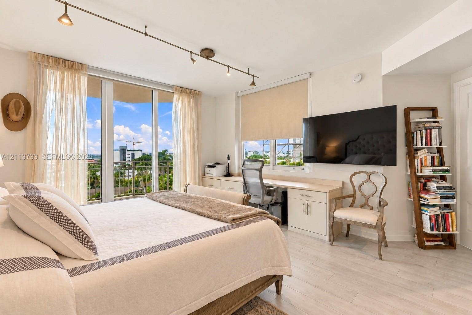 9751 E Bay Harbor Drive, #6A, Bay Harbor Islands, FL 33154 Floor-to-ceiling windows, integrated built-in desk with cabinetry, light-toned wood-finish flooring, and adjustable track lighting
