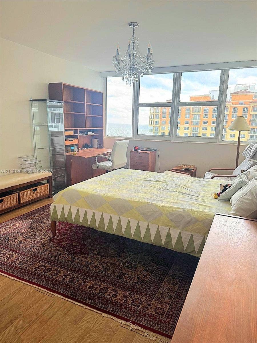 2030 S Ocean Drive, #1719, Hallandale Beach, FL 33009 Floor-to-ceiling windows with coastal horizon backdrop, wood-finish flooring, and decorative crystal chandelier