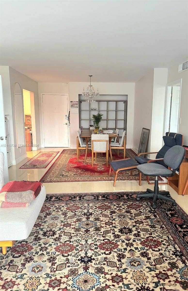 2030 S Ocean Drive, #1719, Hallandale Beach, FL 33009 Living area featuring polished stone-finish flooring, built-in recessed shelving, and a hanging crystal chandelier