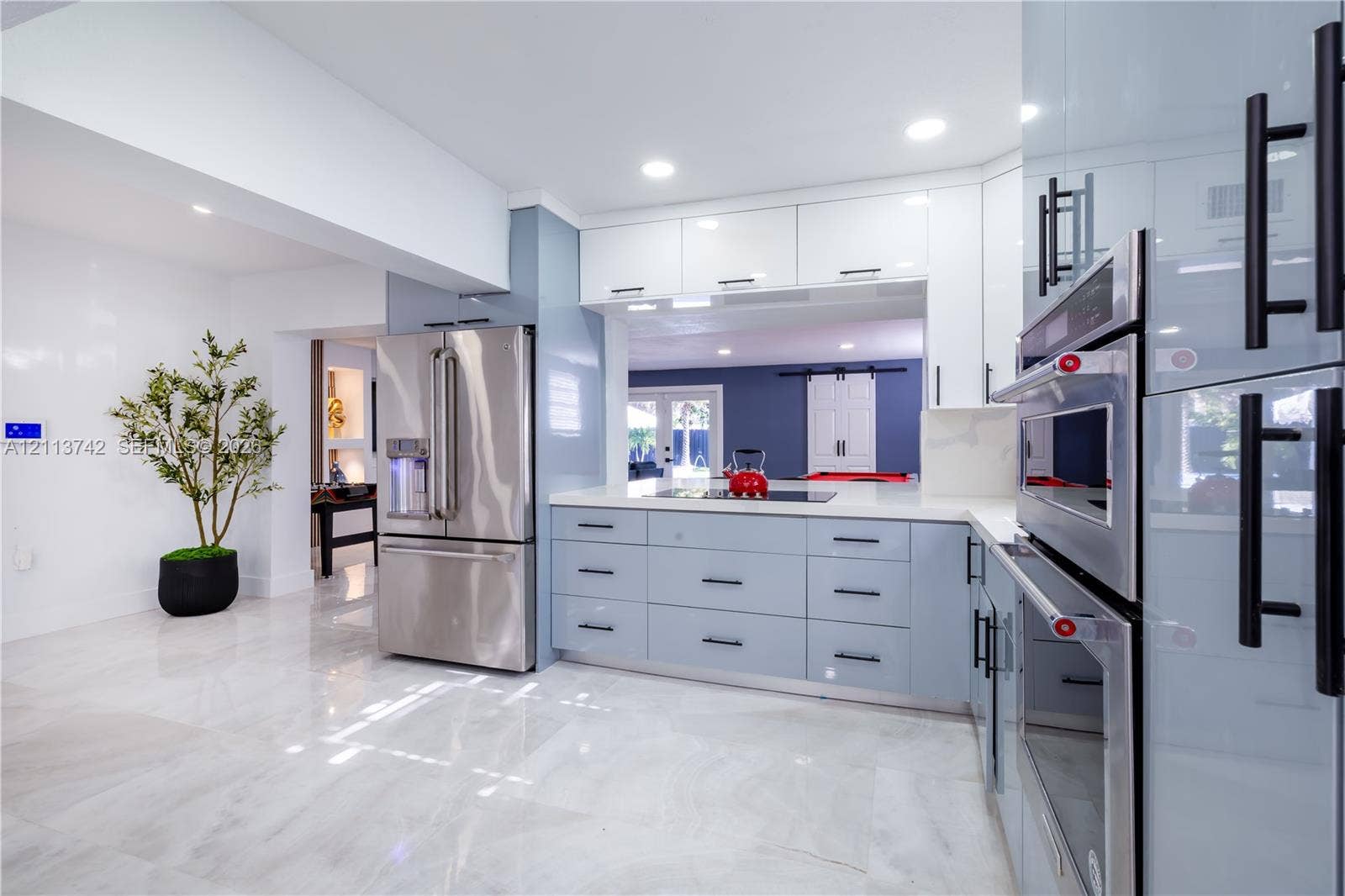 1930 NW 163rd St Road, Miami Gardens, FL 33054 Kitchen featuring high-gloss cabinetry with matte black hardware, stone-finish flooring, stainless steel built-in appliances, and recessed lighting