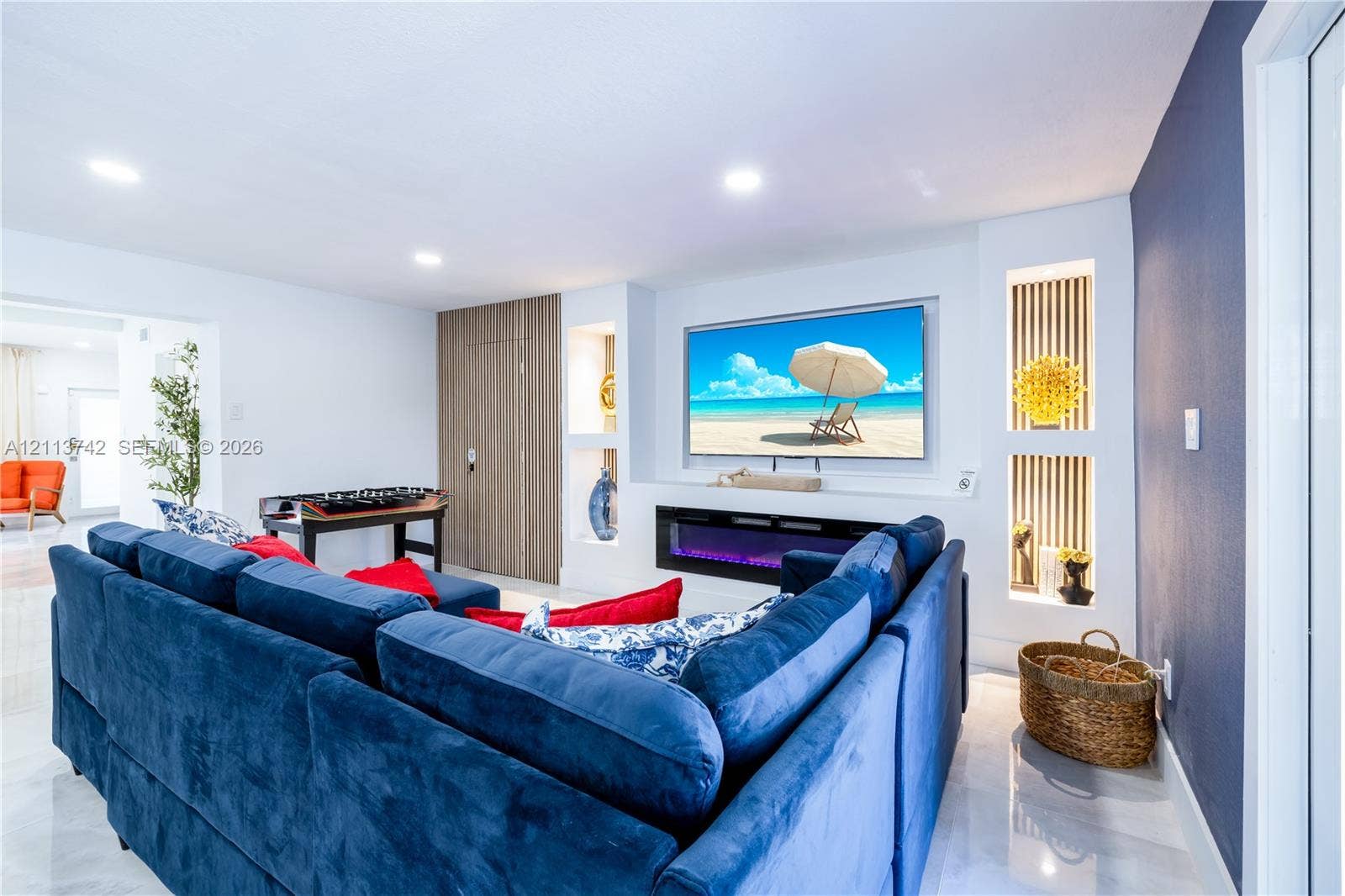 1930 NW 163rd St Road, Miami Gardens, FL 33054 Recessed media wall featuring an electric fireplace, built-in shelving, slat-style accent paneling, and recessed lighting