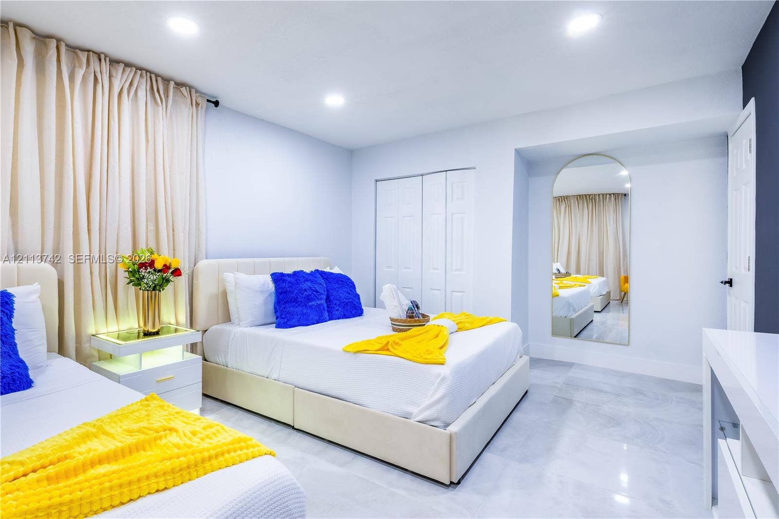 1930 NW 163rd St Road, Miami Gardens, FL 33054 Neutral wall finish, polished stone-finish flooring, recessed lighting, double-door closet with paneled detail, and integrated arch-top wall mirror