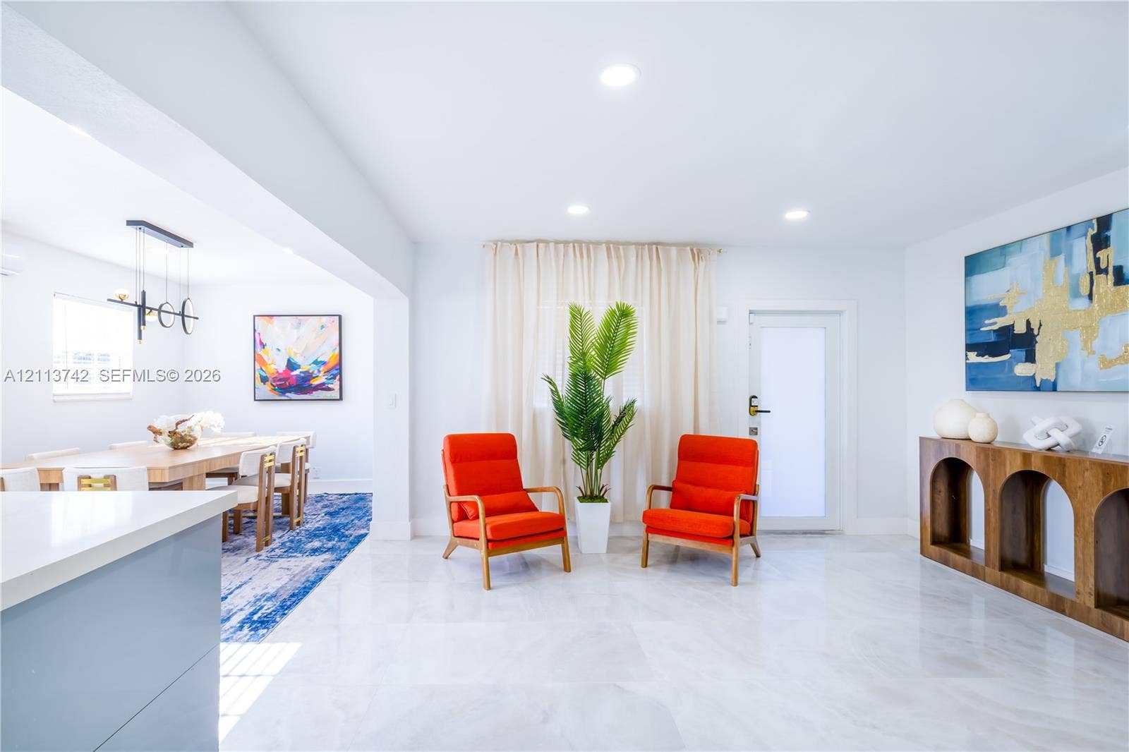1930 NW 163rd St Road, Miami Gardens, FL 33054 Open-concept interior featuring light-toned tile flooring, recessed ceiling lighting, and a modern tiered linear chandelier