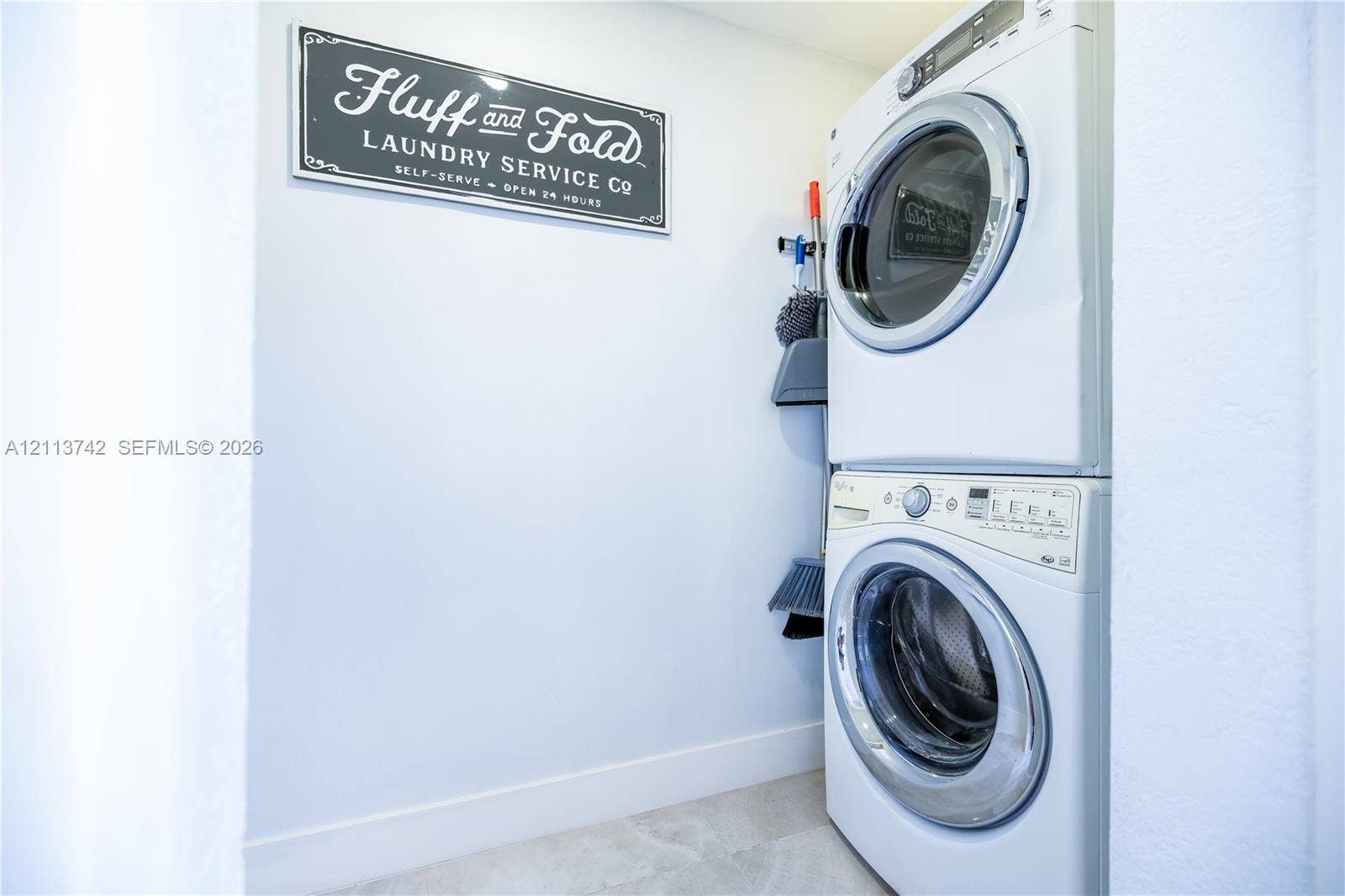 1930 NW 163rd St Road, Miami Gardens, FL 33054 Laundry closet featuring a white stacked washer and dryer set
