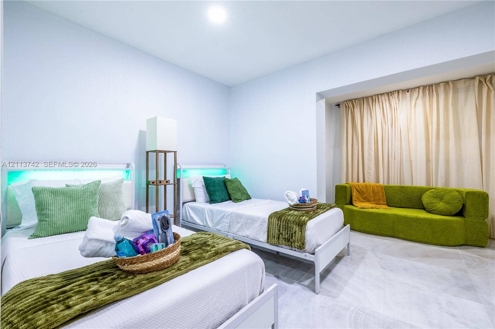 1930 NW 163rd St Road, Miami Gardens, FL 33054 Spacious interior featuring large-format light-tone tile flooring, recessed ceiling lighting, and a recessed window nook with full-length drapery