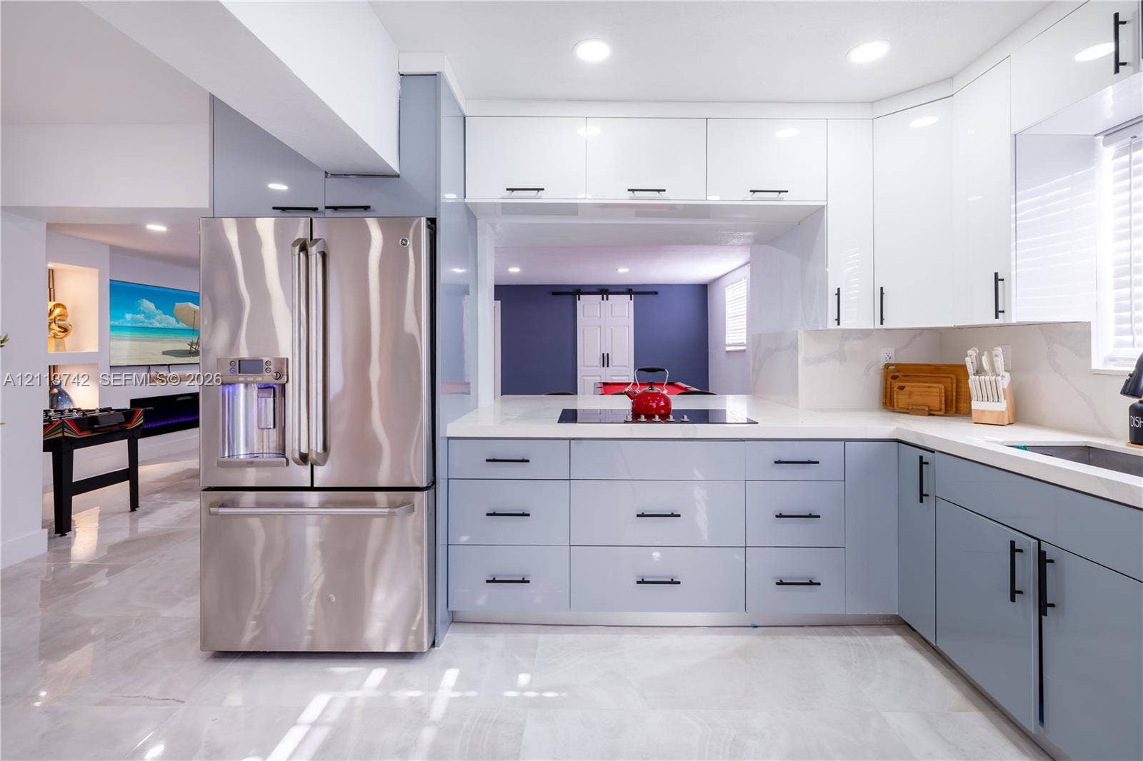 1930 NW 163rd St Road, Miami Gardens, FL 33054 Kitchen featuring gloss-finish cabinetry, stone-surface countertops, integrated stainless steel appliances, recessed lighting, and large-format tile flooring