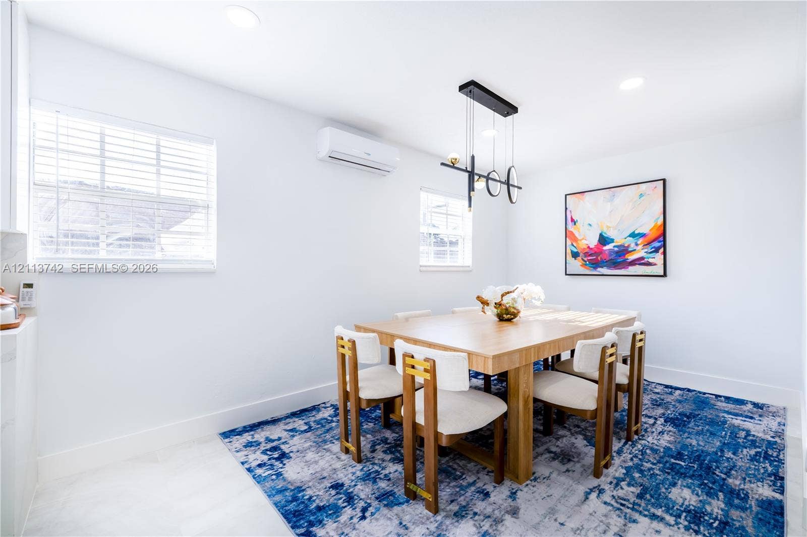 1930 NW 163rd St Road, Miami Gardens, FL 33054 Interior space featuring recessed lighting, a modern multi-pendant geometric light fixture, wall-mounted ductless climate control unit, and window blinds