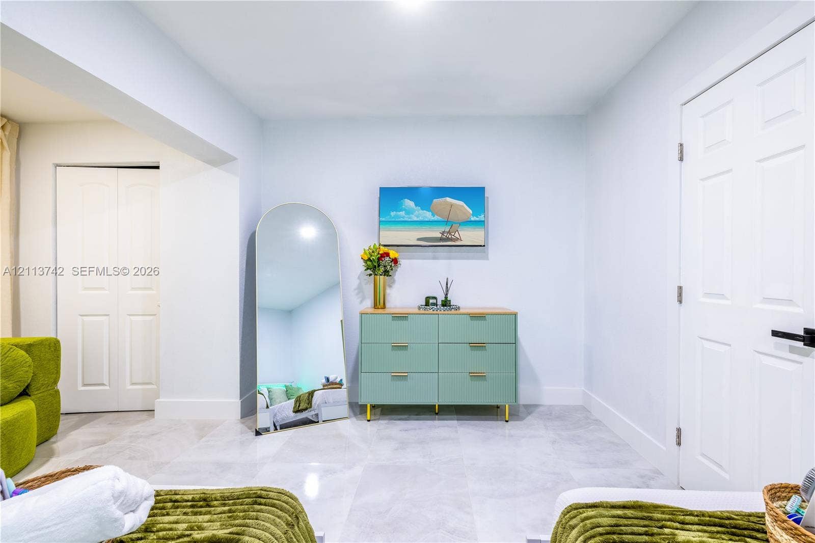 1930 NW 163rd St Road, Miami Gardens, FL 33054 Neutral-toned interior featuring large-format tile flooring, recessed ceiling lighting, and two multi-panel interior doors with matte black hardware