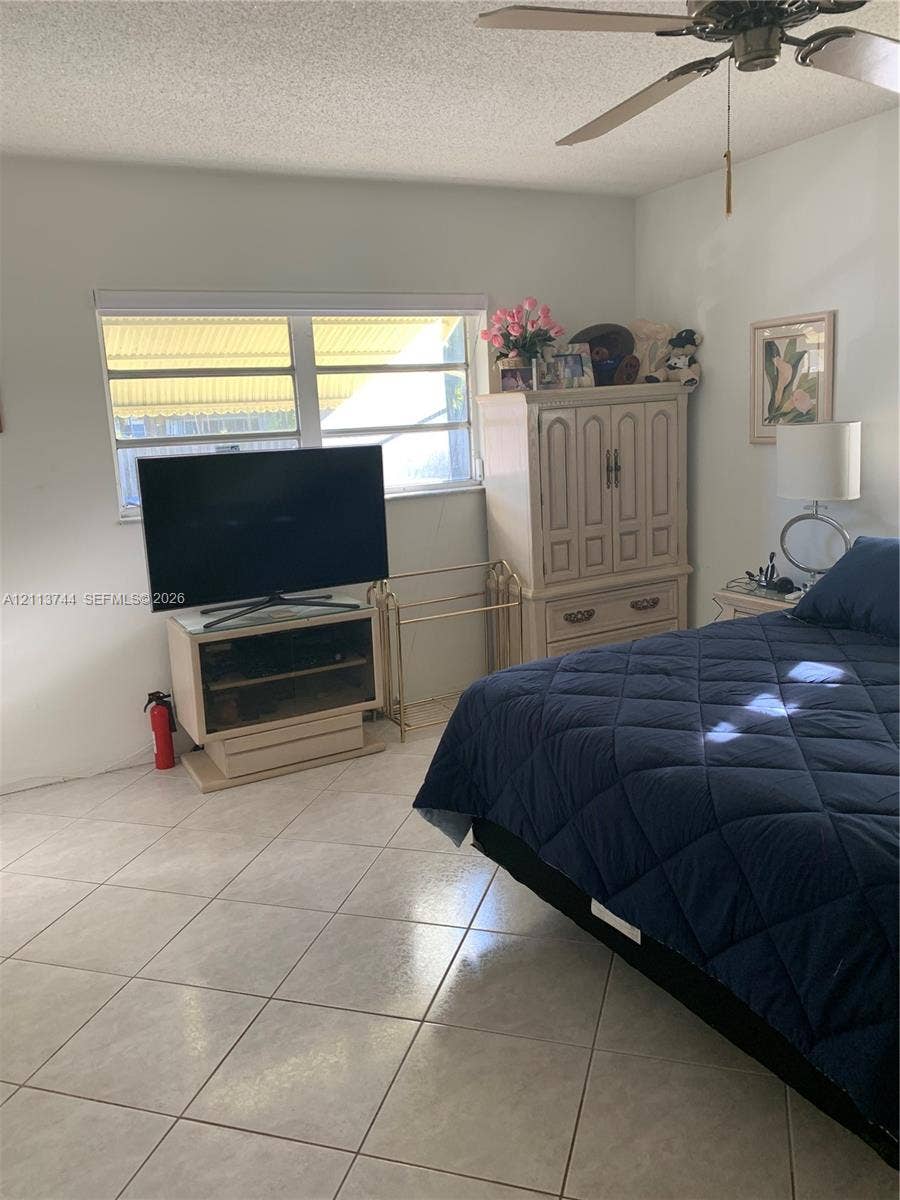 1501 Arthur Street, #1, Hollywood, FL 33020 Neutral-toned ceramic tile flooring, horizontal window with white window shade, and ceiling-mounted fan with light fixture