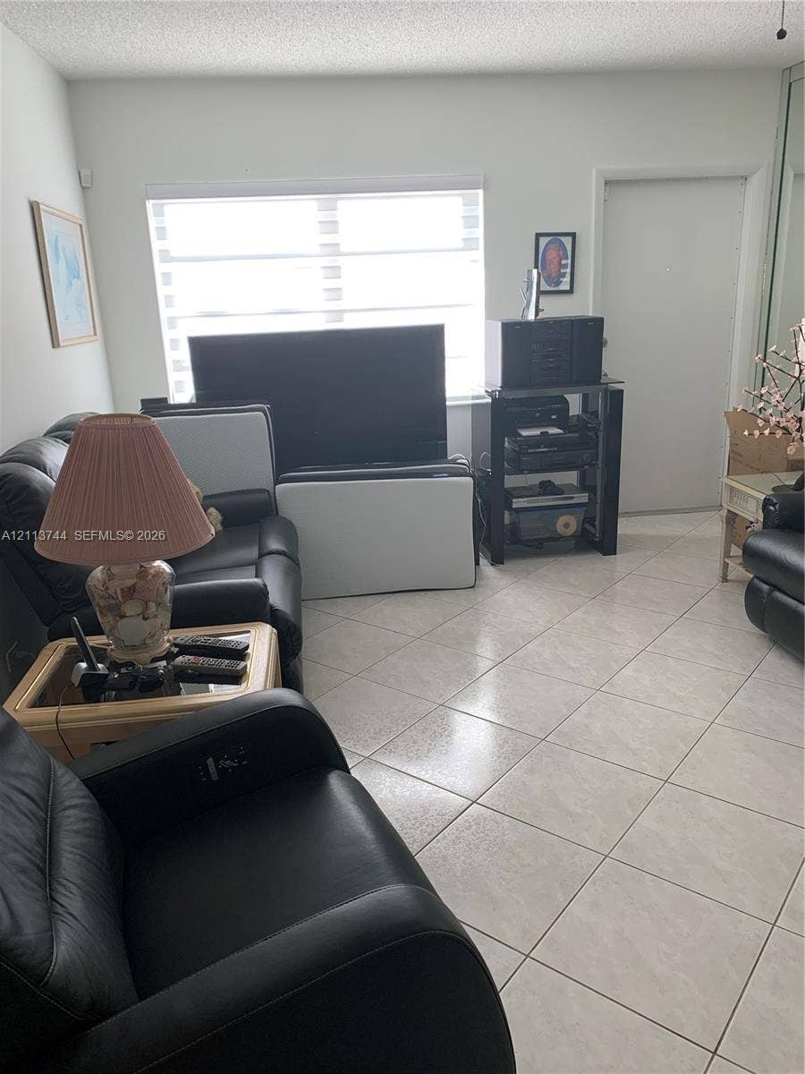 1501 Arthur Street, #1, Hollywood, FL 33020 Neutral-toned ceramic tile flooring, horizontal window shades, and sliding mirrored closet doors