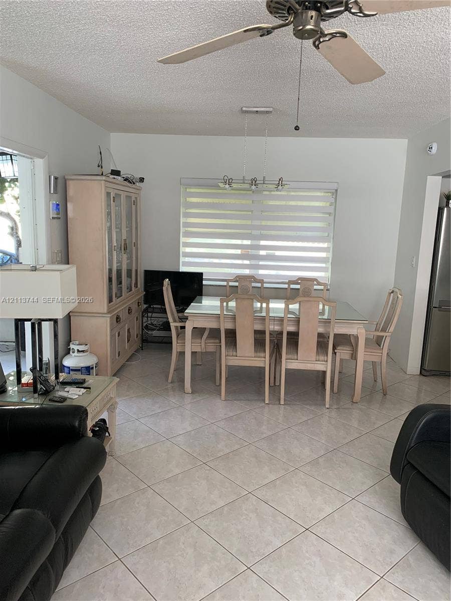 1501 Arthur Street, #1, Hollywood, FL 33020 Light-toned ceramic tile flooring, ceiling fan with light kit, and multi-light linear chandelier