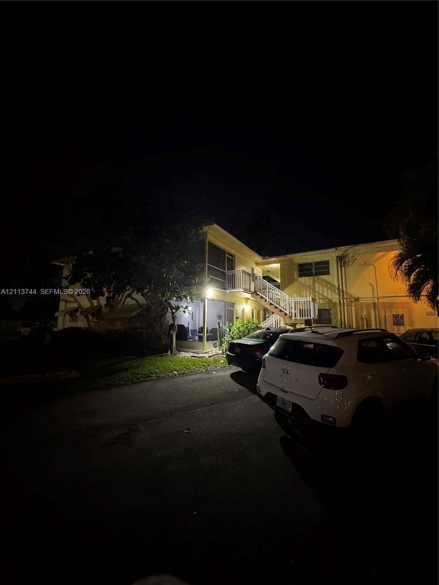 1501 Arthur Street, #1, Hollywood, FL 33020 Multi-story exterior featuring a screened-in lanai, metal railings, and staircase access