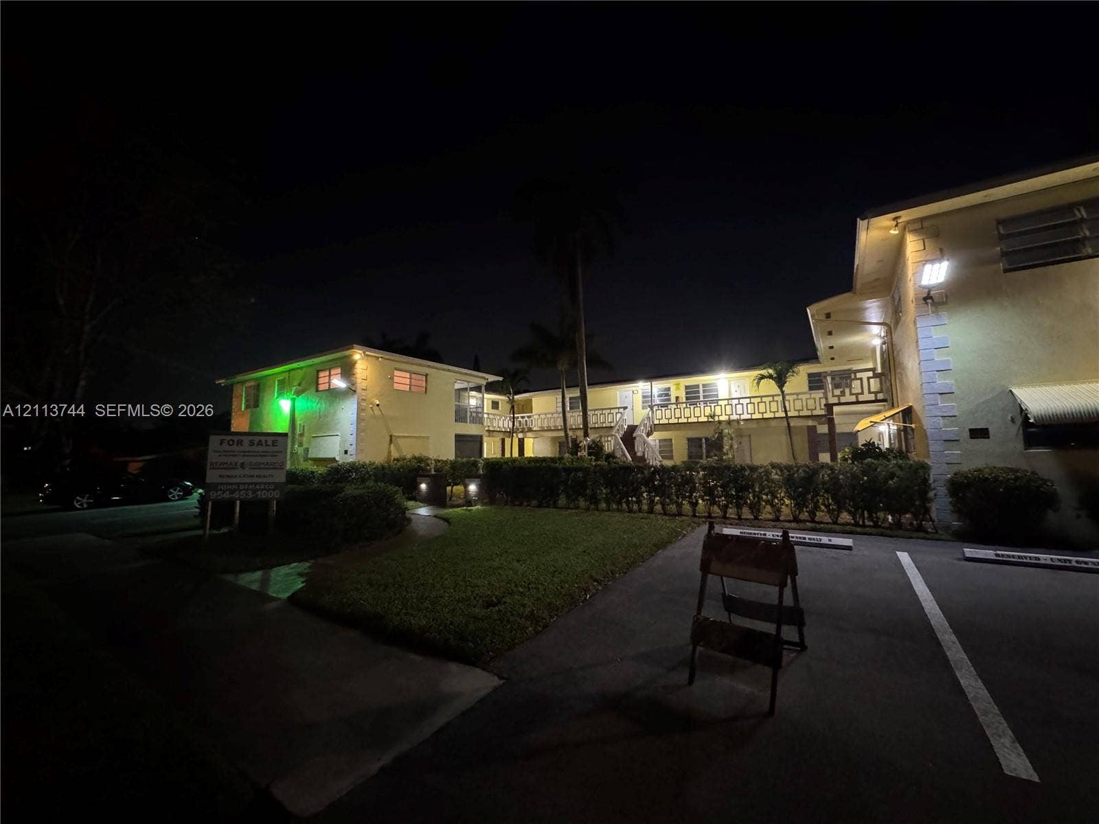 1501 Arthur Street, #1, Hollywood, FL 33020 Multi-story exterior featuring stucco siding, metal railing balconies, paved parking area, and mature palm trees