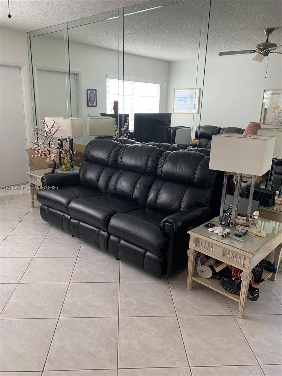 1501 Arthur Street, #1, Hollywood, FL 33020 Living area featuring large-format ceramic tile flooring, floor-to-ceiling wall-mounted mirrors, and a ceiling-mounted fan