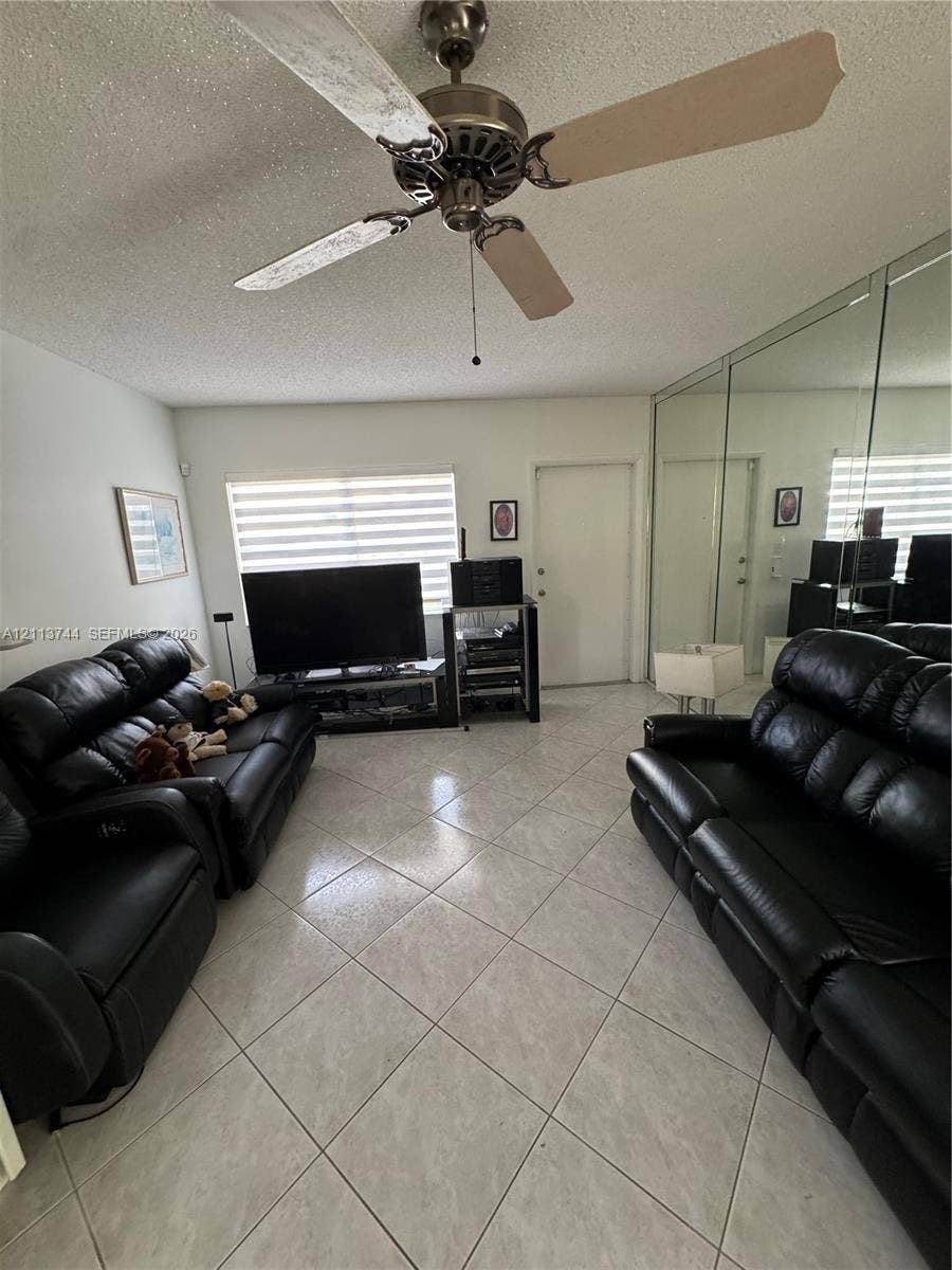 1501 Arthur Street, #1, Hollywood, FL 33020 Ceramic tile flooring, full-wall mirrored closet doors, ceiling fan with light fixture, and dual-layered window shades