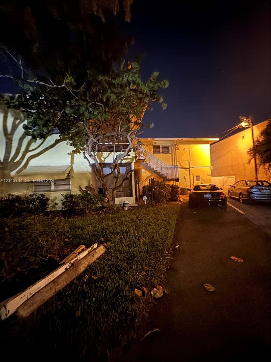 1501 Arthur Street, #1, Hollywood, FL 33020 Exterior featuring a multi-story building with white metal staircases, louvered window awnings, and an asphalt paved driveway