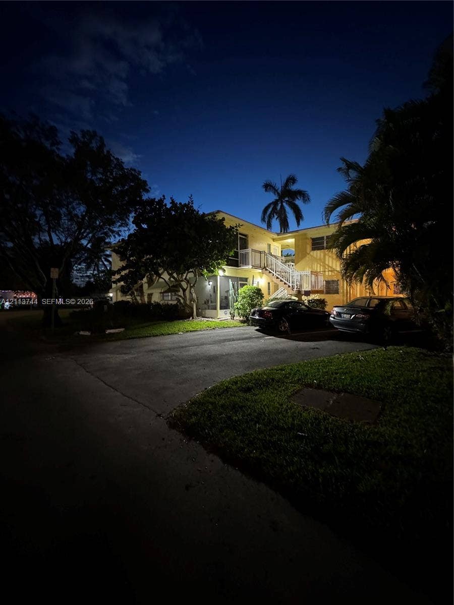 1501 Arthur Street, #1, Hollywood, FL 33020 Multi-story exterior featuring concrete masonry construction, exterior staircase, balcony railings, and paved surface parking