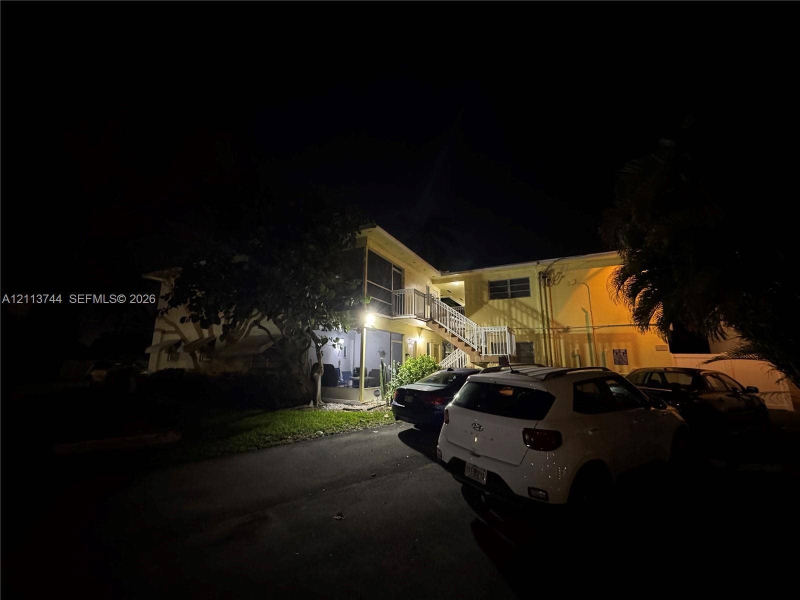 1501 Arthur Street, #1, Hollywood, FL 33020 Multi-story exterior featuring a screened-in ground level, balcony, and external staircase with white railings