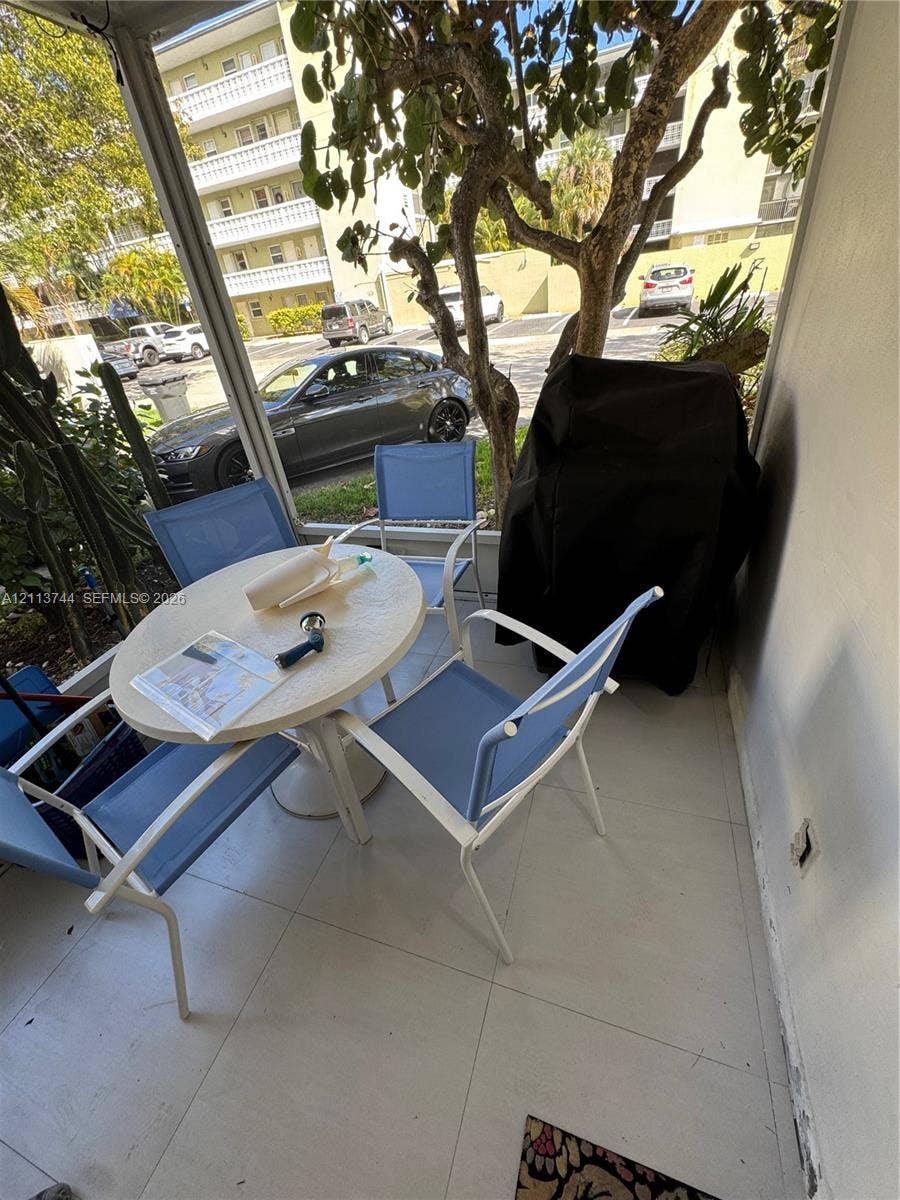 1501 Arthur Street, #1, Hollywood, FL 33020 Screened-in patio featuring large-format tile flooring and vertical mesh enclosure