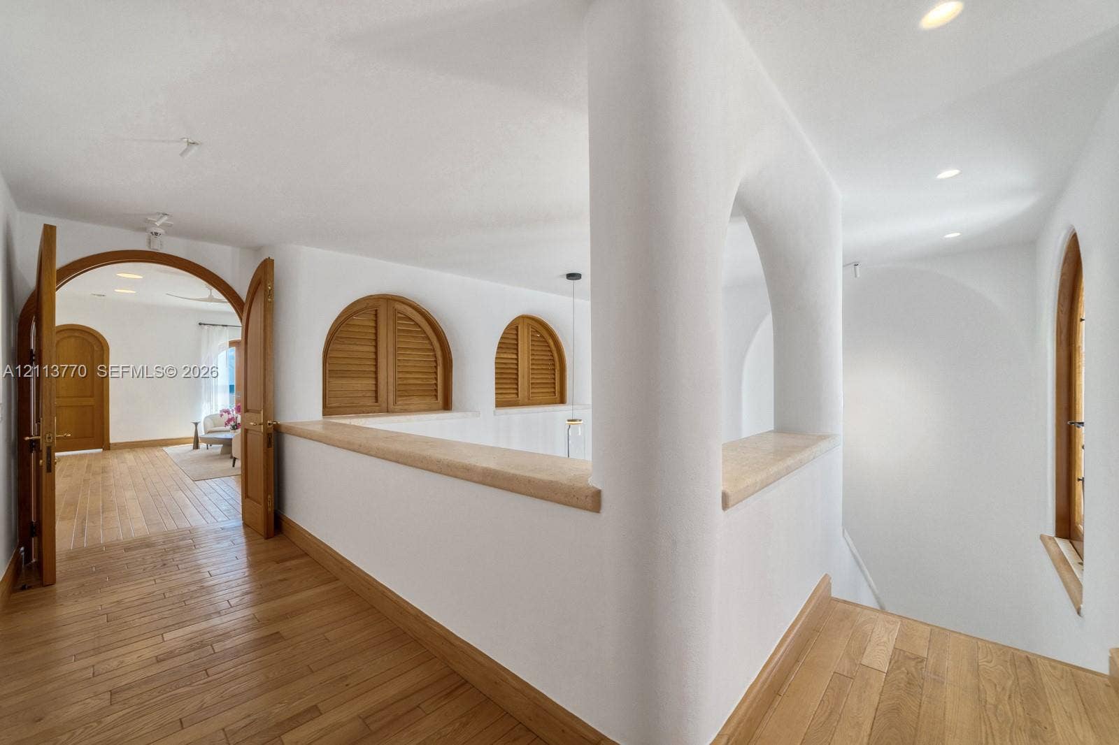 387 Ocean Boulevard, Golden Beach, Golden Beach, FL 33160 Arched architectural openings, smooth plaster wall finishes, wood-finish flooring, recessed lighting, and wooden louvered shutters