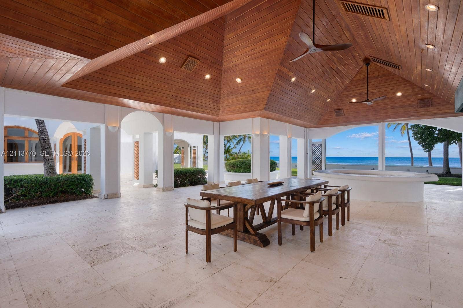 387 Ocean Boulevard, Golden Beach, Golden Beach, FL 33160 Covered outdoor pavilion featuring a vaulted wood-plank ceiling, recessed lighting, ceiling fans, stone flooring, and a built-in circular masonry counter