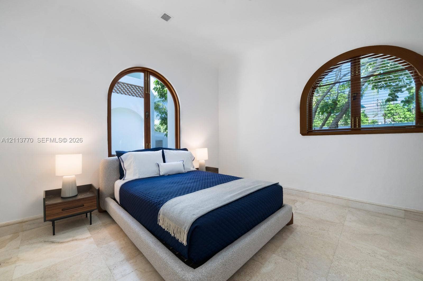 387 Ocean Boulevard, Golden Beach, Golden Beach, FL 33160 Natural stone flooring paired with dual arched windows featuring dark wood-finish framing