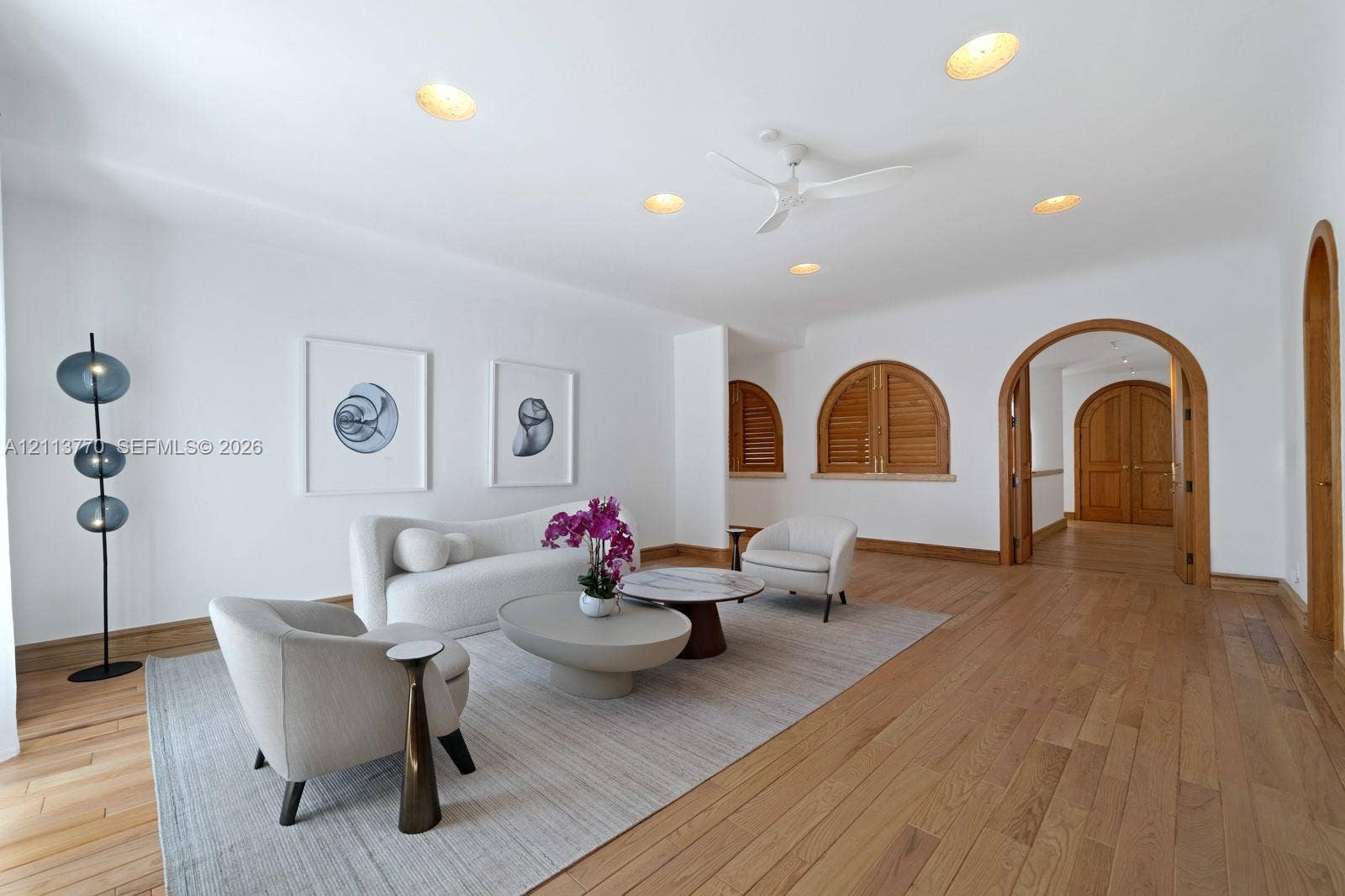 387 Ocean Boulevard, Golden Beach, Golden Beach, FL 33160 Living space featuring wood-finish flooring, recessed lighting, ceiling fan, arched doorways with wood trim, and arched window shutters