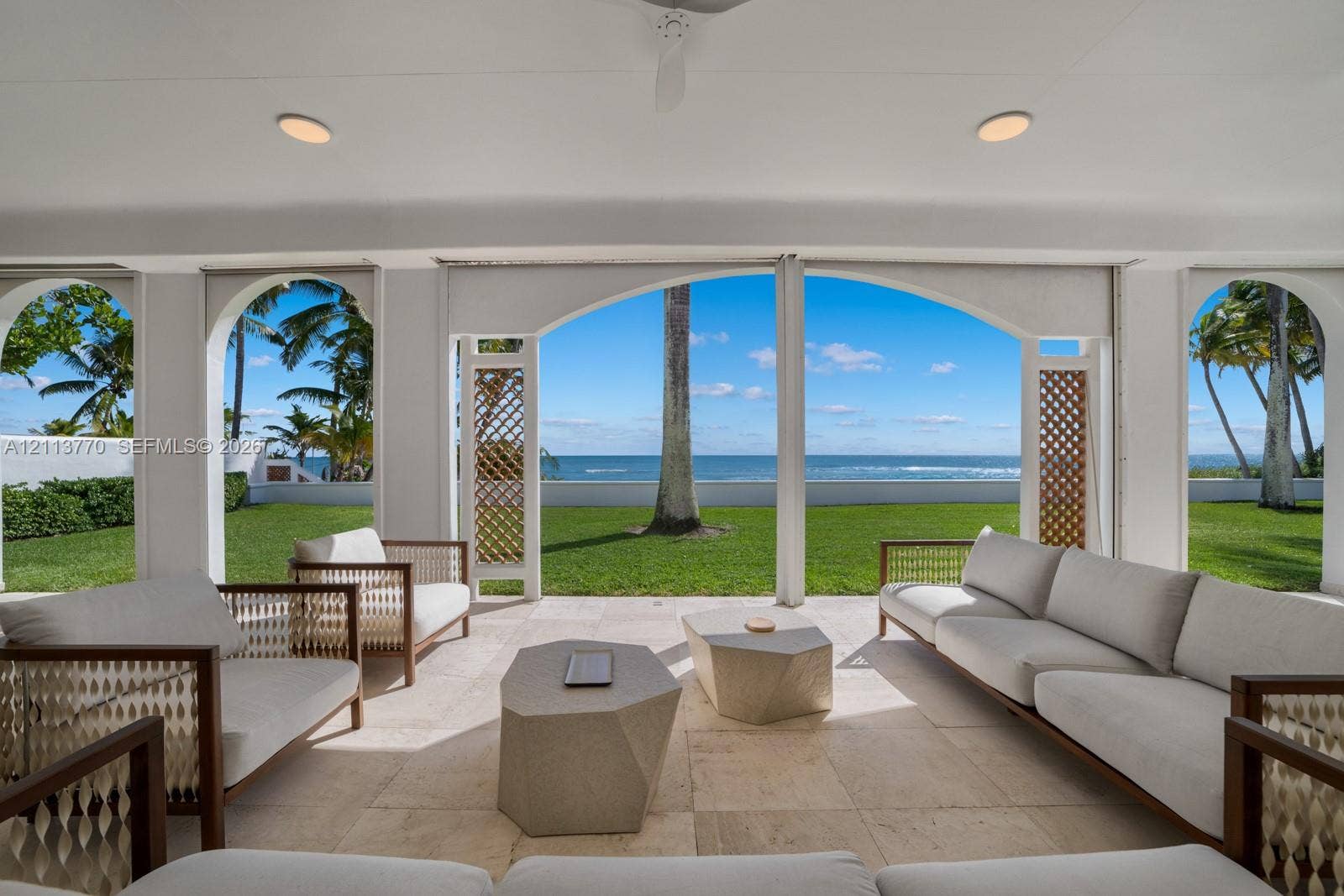 387 Ocean Boulevard, Golden Beach, Golden Beach, FL 33160 Covered loggia featuring stone flooring, arched openings, recessed lighting, and decorative latticework