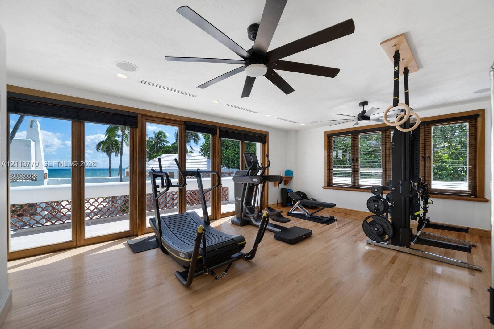 387 Ocean Boulevard, Golden Beach, Golden Beach, FL 33160 Wood-finish flooring, floor-to-ceiling glass panel doors, recessed ceiling lighting, multi-blade ceiling fans, and natural wood window casing