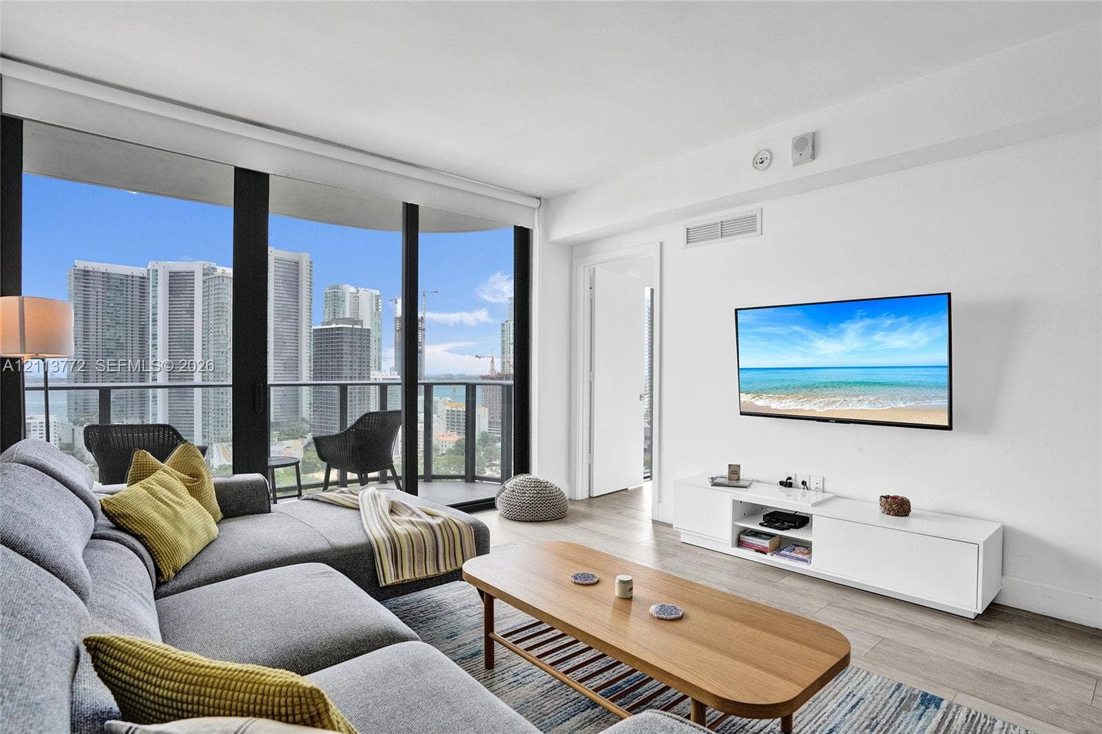 Floor-to-ceiling windows, wood-finish flooring, and private balcony