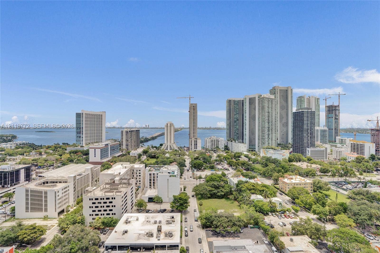 Elevated urban perspective featuring panoramic city skyline, waterfront horizon, and expansive metropolitan landscape