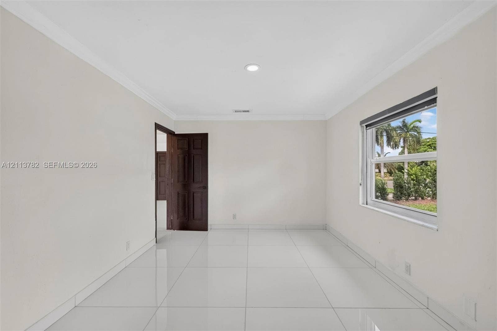 4720 Bayview Drive, Fort Lauderdale, FL 33308 Interior space featuring large-format tile flooring, crown molding, recessed lighting, and a multi-panel wood door