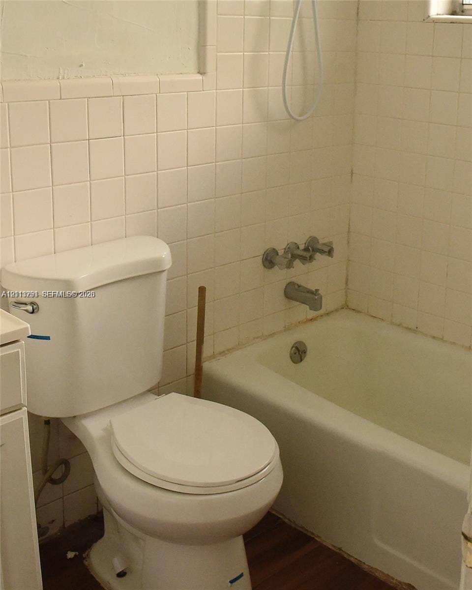 716 SE 18th Street, #1, Fort Lauderdale, Fort Lauderdale, FL 33316 Bathroom featuring a white porcelain toilet, integrated bathtub and shower combination, and wall-mounted metallic fixtures